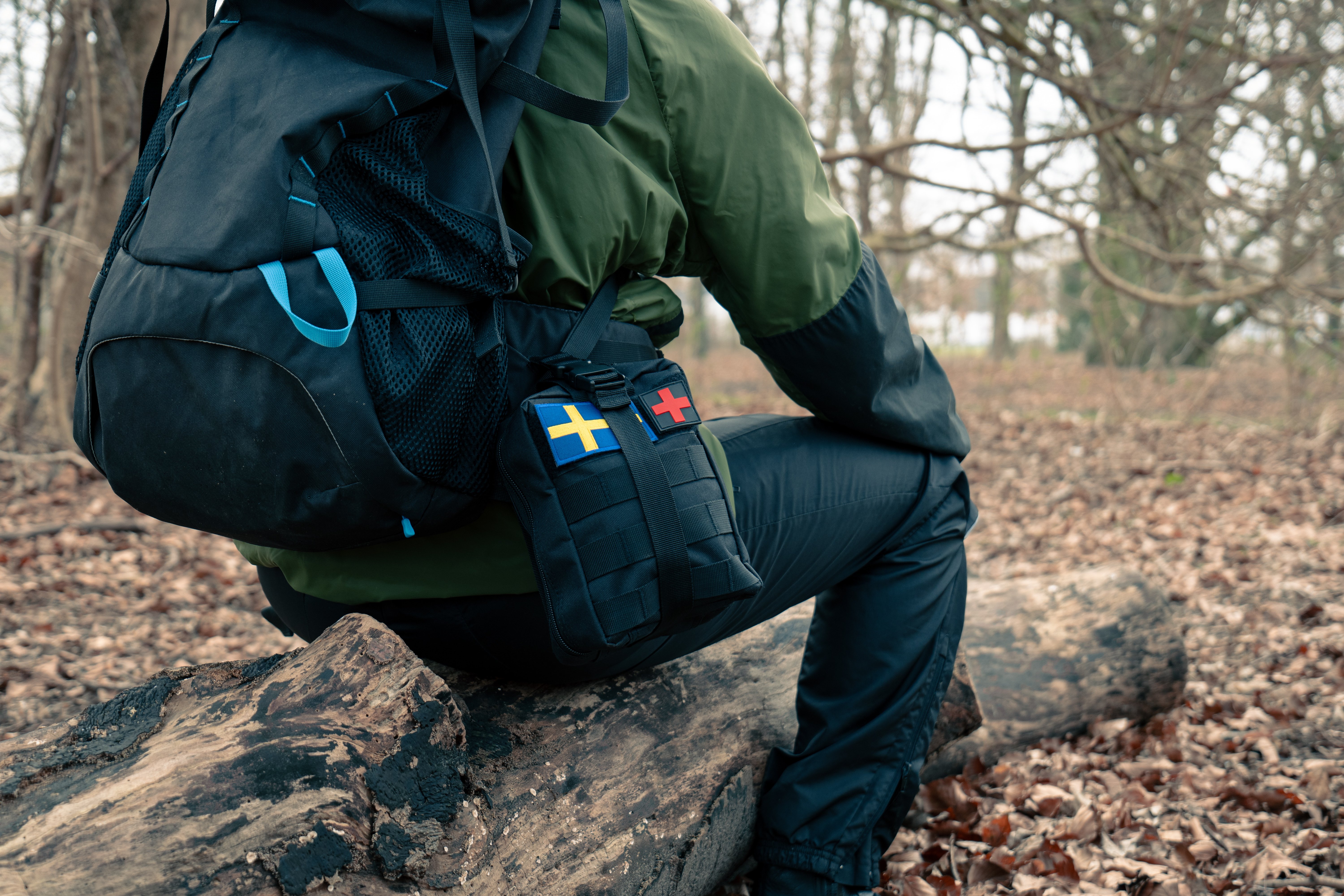 A person wearing a survival kit in a forested area