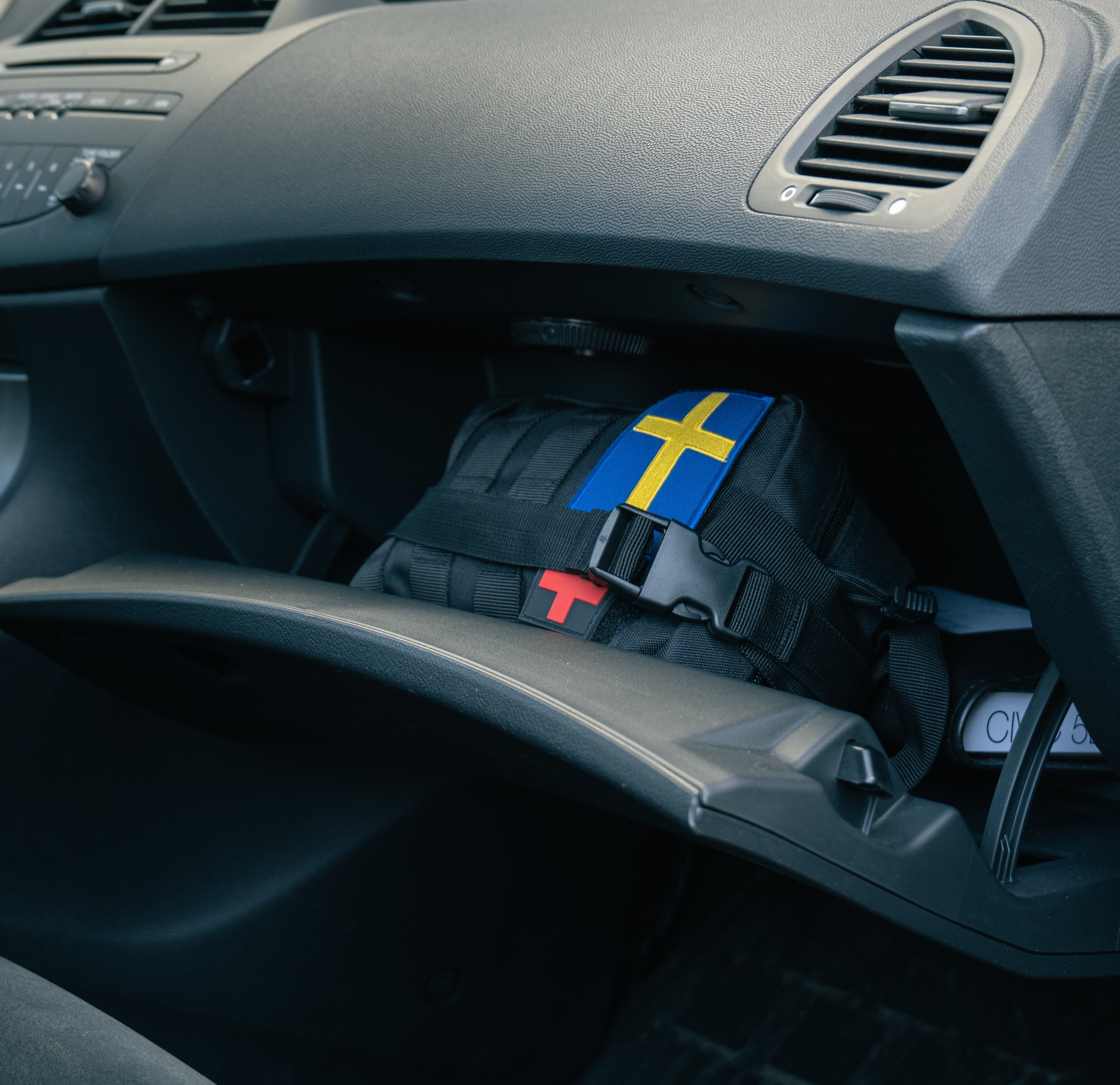 A survival kit inside the open glove compartment of a car
